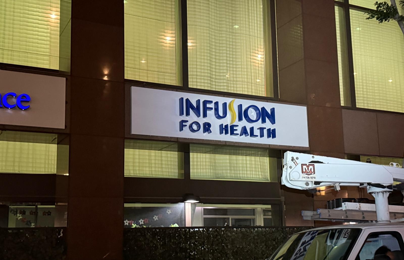 Infusion for Health exterior building sign with blue dimensional letters installed from a lift