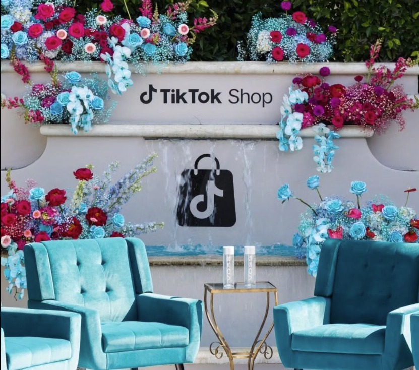 TikTok Shop dimensional wordmark and bag logo mounted on a floral fountain wall at a brand activation